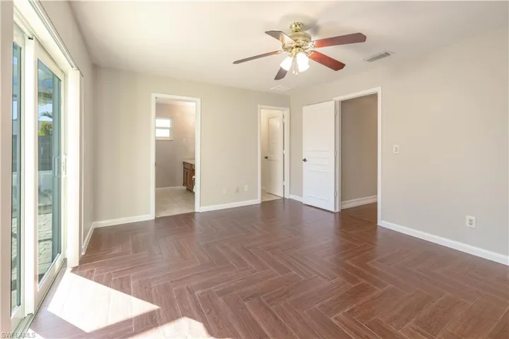 Empty room featuring visible vents, baseboards, and ceiling fan