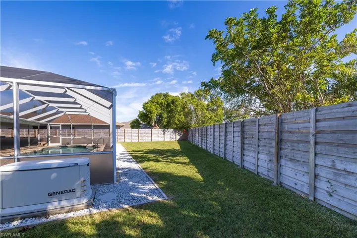 View of yard featuring a fenced backyard, glass enclosure, and a pool