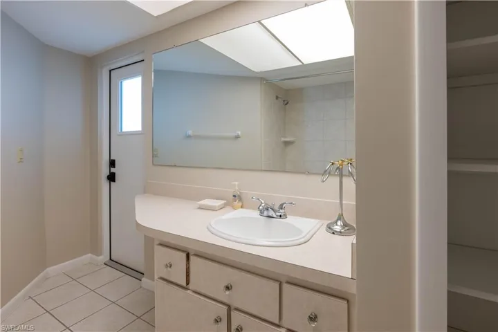 Bathroom with vanity, baseboards, and tile patterned flooring