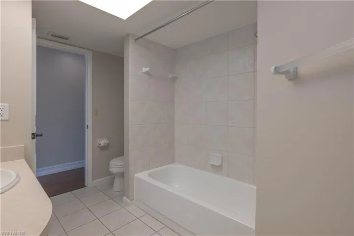Full bath featuring shower / bathtub combination, vanity, tile patterned flooring, visible vents, and toilet