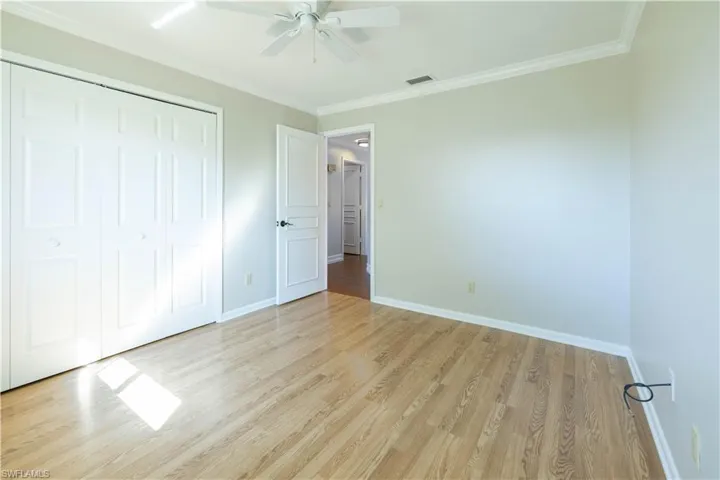Unfurnished bedroom featuring light wood-style floors, visible vents, baseboards, and a closet