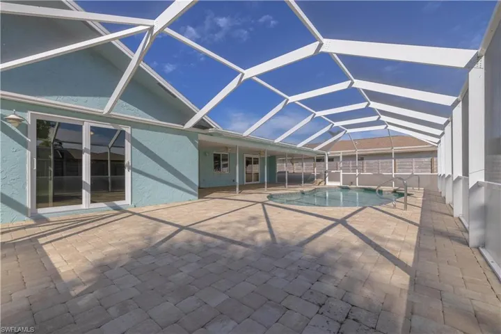 Pool featuring a patio area and glass enclosure
