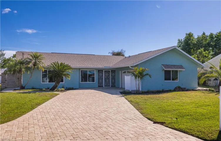 Single story home featuring a front yard, roof with shingles, decorative driveway, and stucco siding