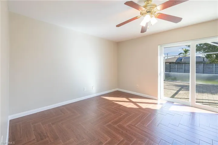 Empty room featuring ceiling fan and baseboards