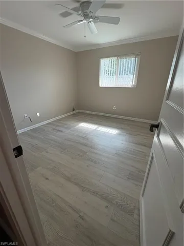 Unfurnished room featuring light wood-style flooring and crown molding