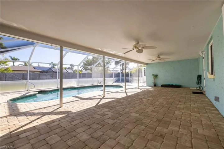 View of pool with a patio area, a ceiling fan, a fenced in pool, and glass enclosure