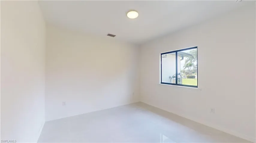 Empty room featuring baseboards and light tile patterned floors