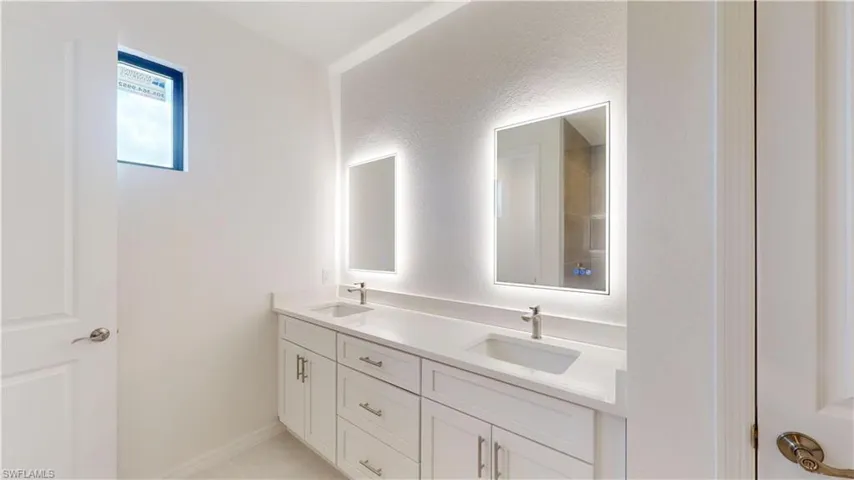 Bathroom featuring double vanity and baseboards