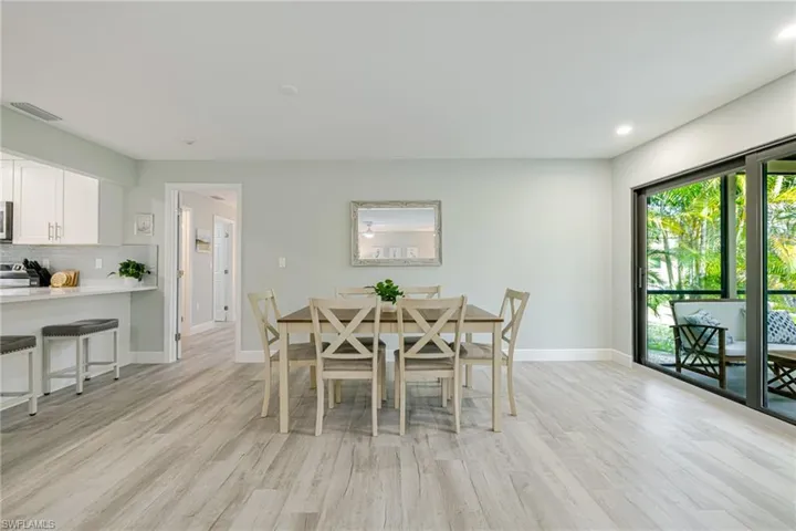 Dining room with light wood finished floors and recessed lighting