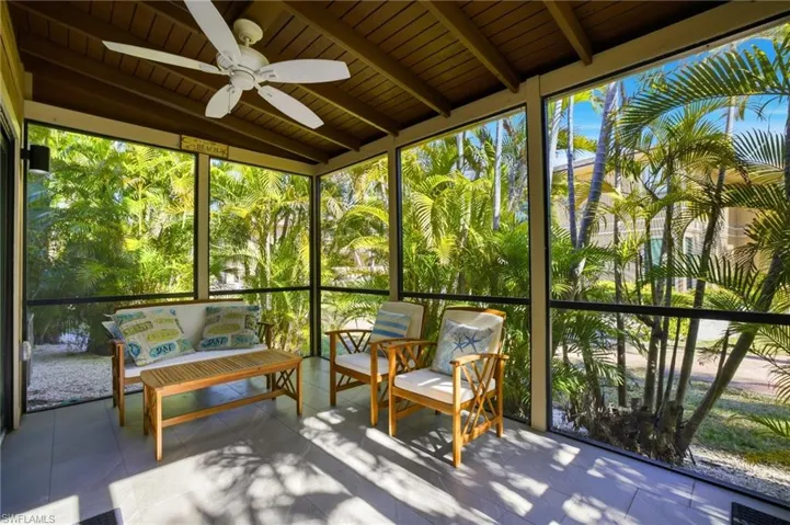 Sunroom with a ceiling fan, beam ceiling, and outdoor furniture