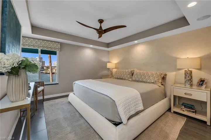 Primary Bedroom has chic textured walls and view of the Bay.