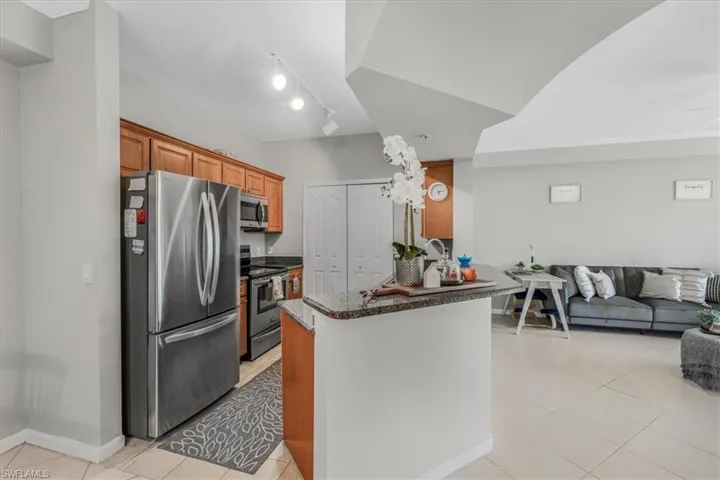 Kitchen with appliances with stainless steel finishes, light tile patterned floors, open floor plan, and a peninsula