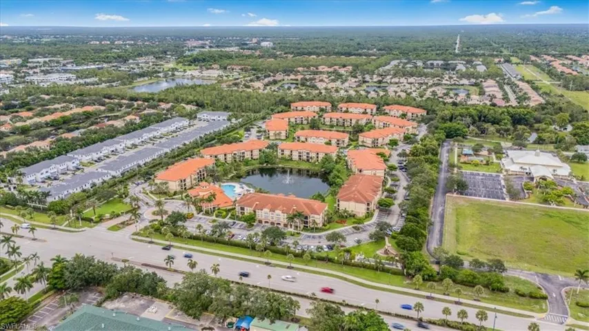 Aerial view of property and surrounding area with a nearby body of water and nearby suburban area