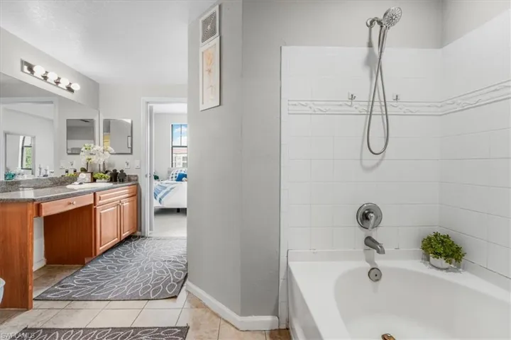 Bathroom with vanity, plenty of natural light, connected bathroom, and tile patterned flooring