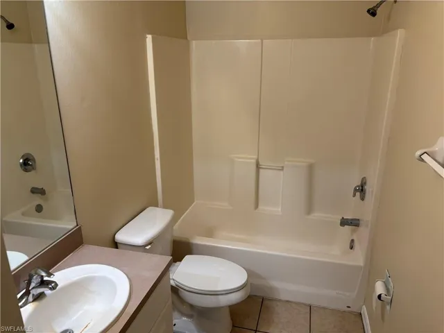 Full bath with shower / washtub combination, vanity, and tile patterned flooring