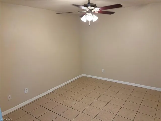 Unfurnished room with light tile patterned flooring and a ceiling fan