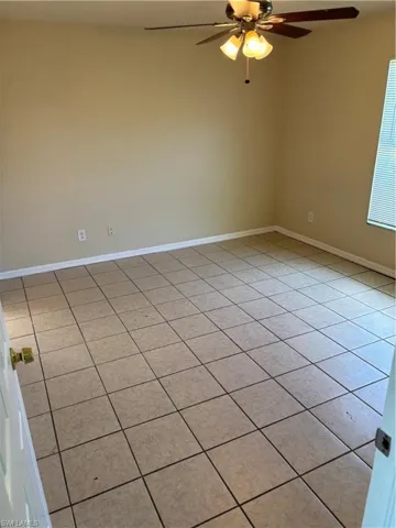 Unfurnished room with light tile patterned flooring and a ceiling fan