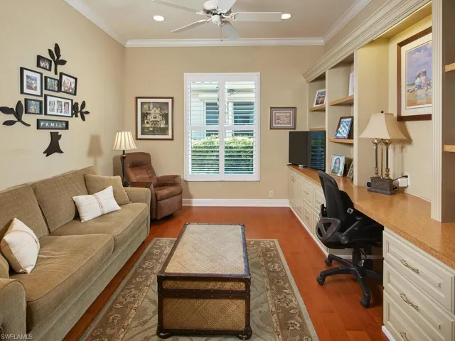 Den/Office, wood flooring, built in custom desk and wall to wall shelving, storage drawers.