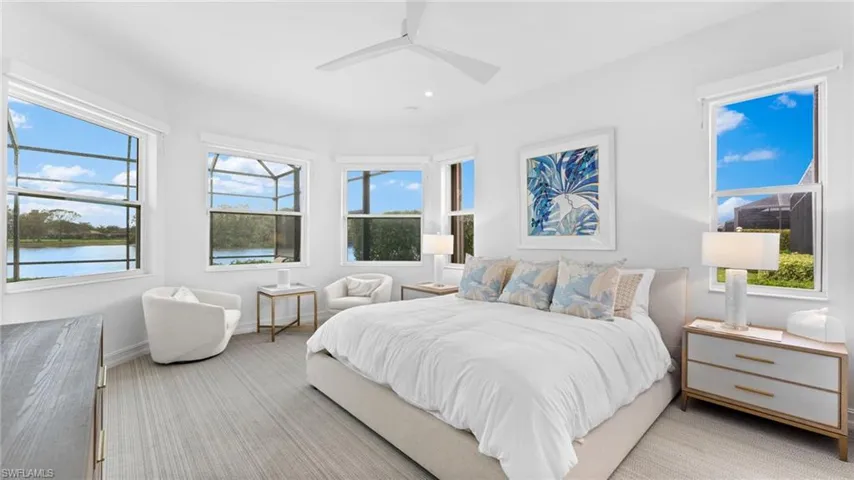 Carpeted bedroom featuring a water view, multiple windows, and ceiling fan