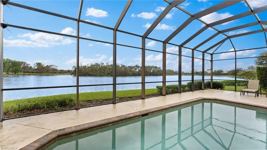 View of swimming pool featuring a lanai, a patio, and a water view