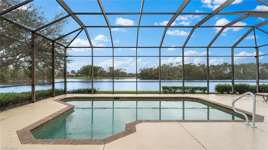 View of pool featuring a water view, glass enclosure, and a patio