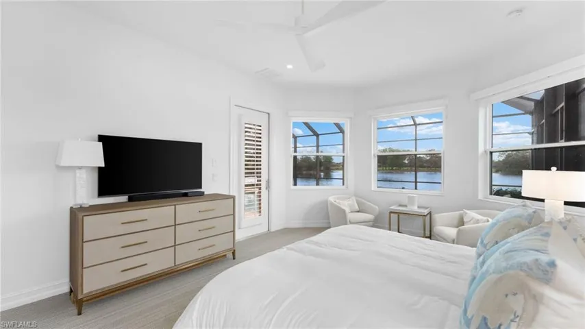 Bedroom featuring multiple windows, access to outside, ceiling fan, and light carpet