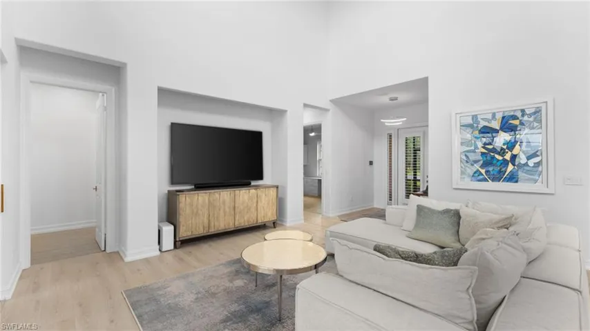 Living room with a high ceiling and light hardwood / wood-style flooring