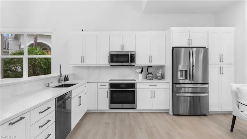Kitchen featuring white cabinets, sink, and stainless steel appliances