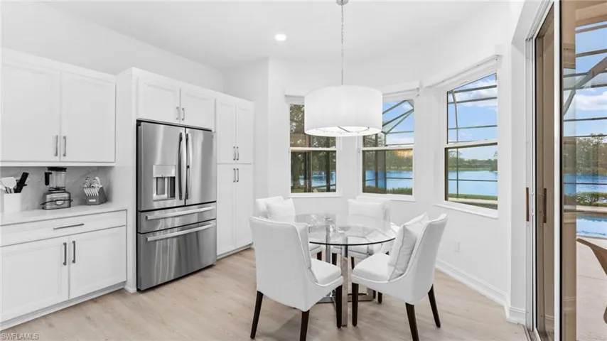 Dining space featuring light wood-type flooring and a water view