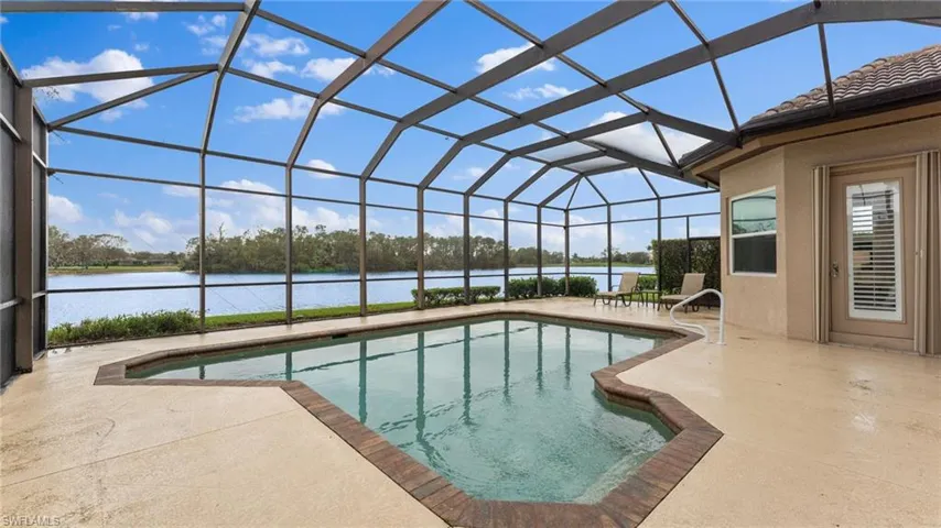 View of pool with a lanai, a water view, and a patio