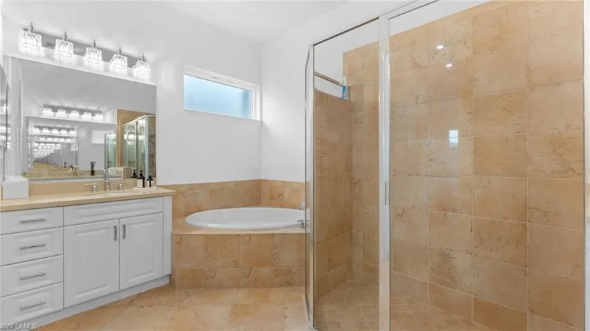 Bathroom with tile patterned flooring, vanity, and independent shower and bath