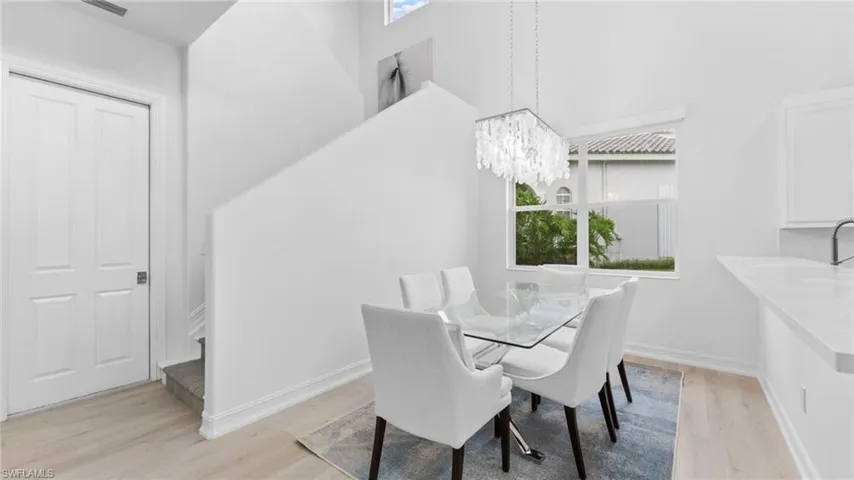 Dining room featuring a towering ceiling and light hardwood / wood-style flooring