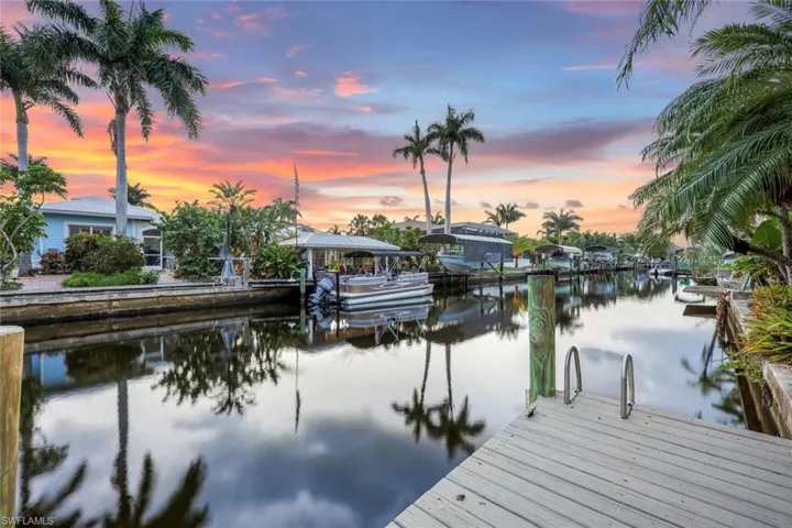 Gentle ripples reflect shades of orange and pink, while the quiet surroundings offer a peaceful, intimate escape by the water.
