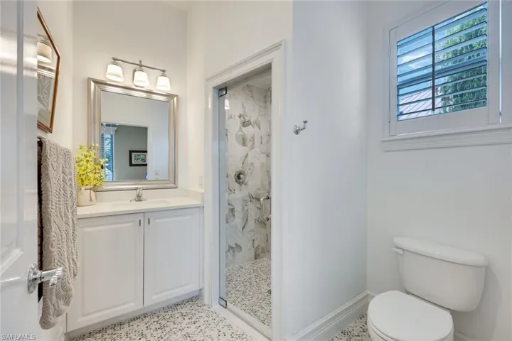 Gorgeous guest bathroom with walk-in shower and floor to ceiling decorative tile.