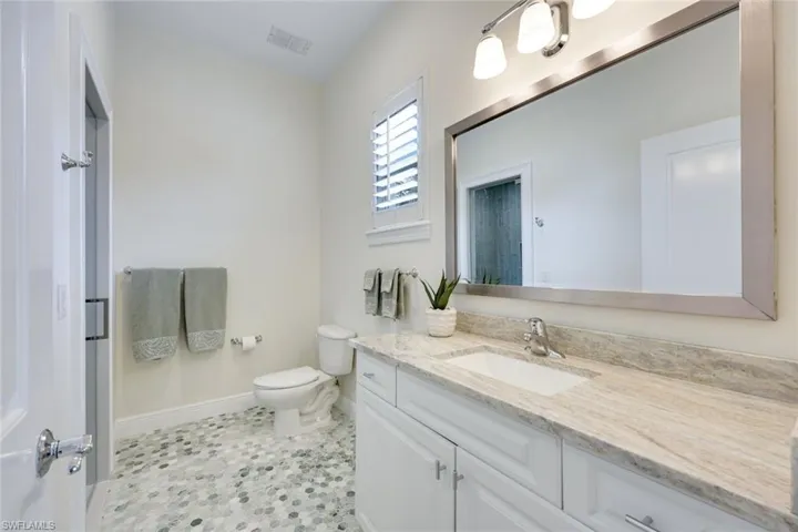 Ensuite guest bathroom has been elegantly updated, featuring a walk-in shower.