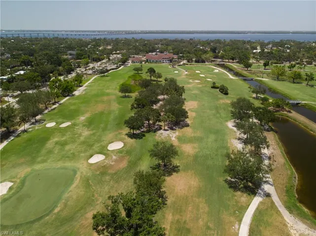 Aerial view of property's location featuring a golf club and a nearby body of water