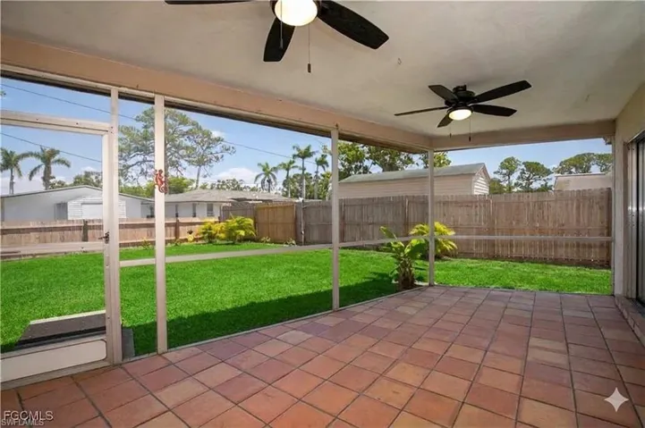 Unfurnished sunroom featuring a ceiling fan
