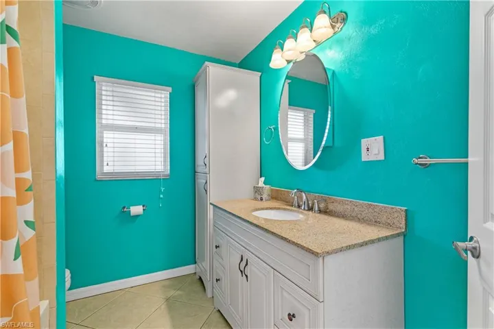 Bathroom with vanity, light tile patterned flooring, and a shower with curtain
