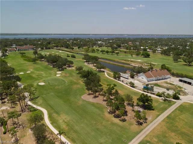 Aerial overview of property's location featuring a local golf course and a large body of water