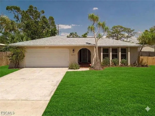 Ranch-style house featuring an attached garage, concrete driveway, and stucco siding