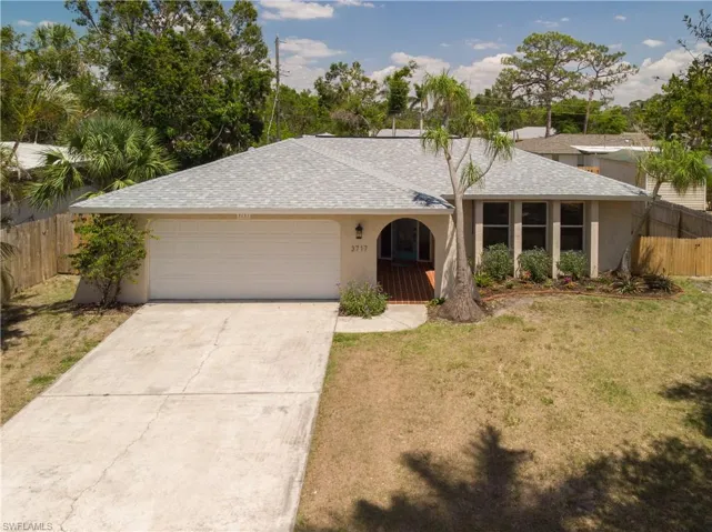 Single story home with driveway, stucco siding, a garage, and roof with shingles
