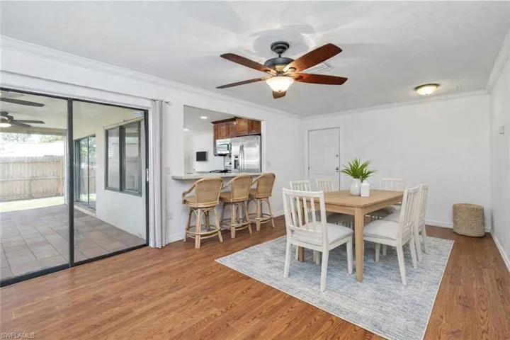 Dining room with ceiling fan, crown molding, and wood finished floors