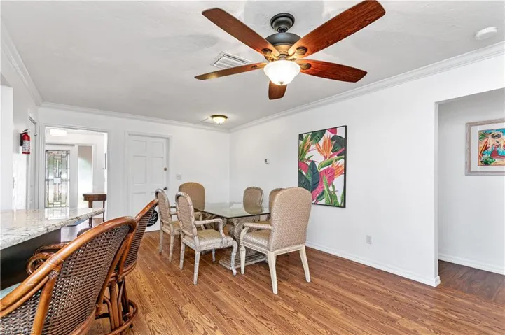 Dining room featuring crown molding, light wood-style flooring, and a ceiling fan