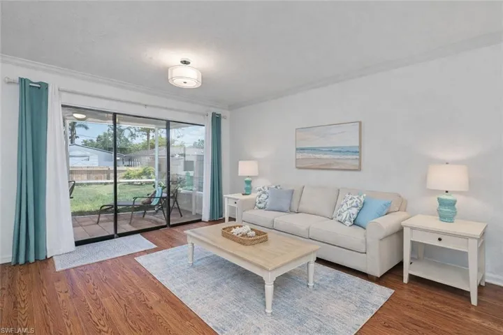 Living room with dark wood-style floors and crown molding