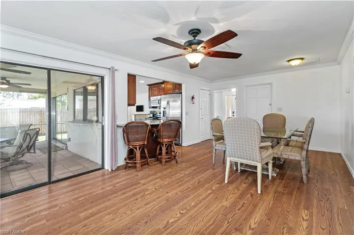Dining area with ceiling fan, crown molding, and light wood-style floors