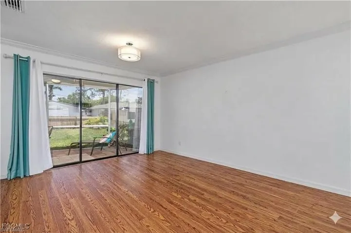 Unfurnished room featuring wood finished floors and crown molding