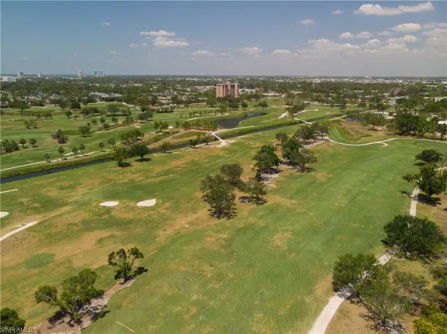 Aerial view of property's location with a local golf course and a nearby body of water