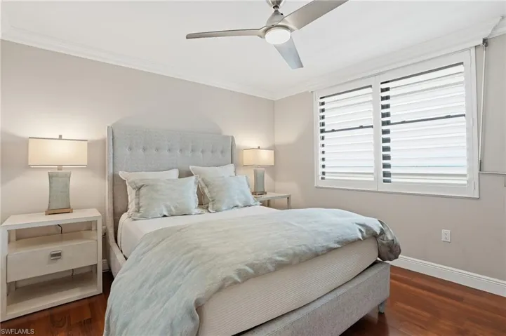 Guest bedroom features plantation shutters and natural light