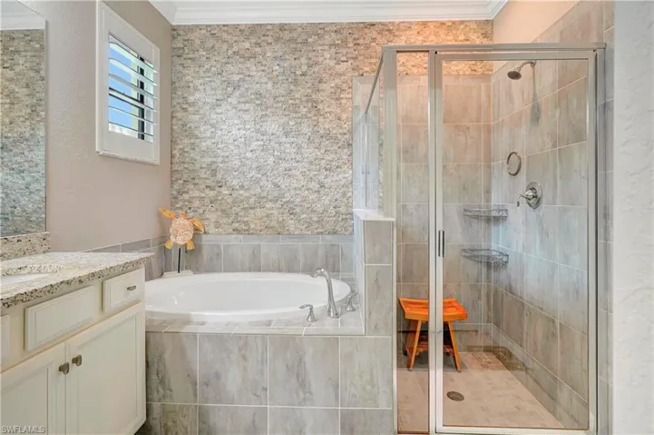 Bathroom featuring vanity, shower with separate bathtub, and ornamental molding