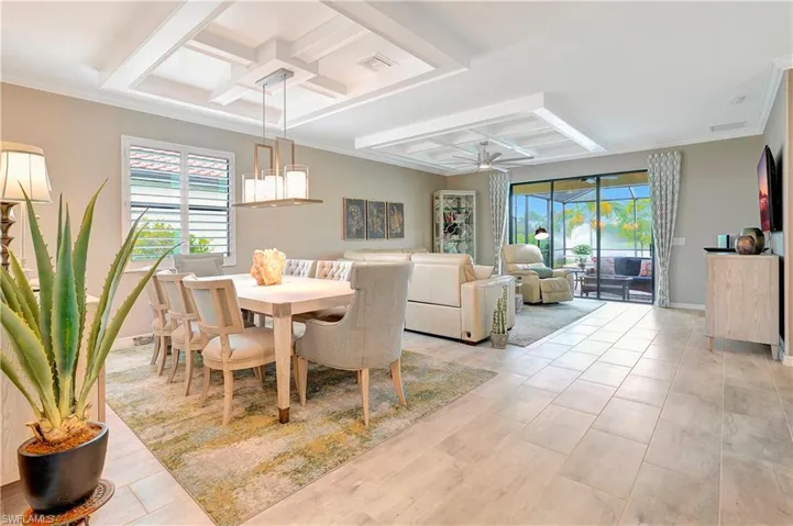Dining room with beamed ceiling, crown molding, coffered ceiling, and ceiling fan